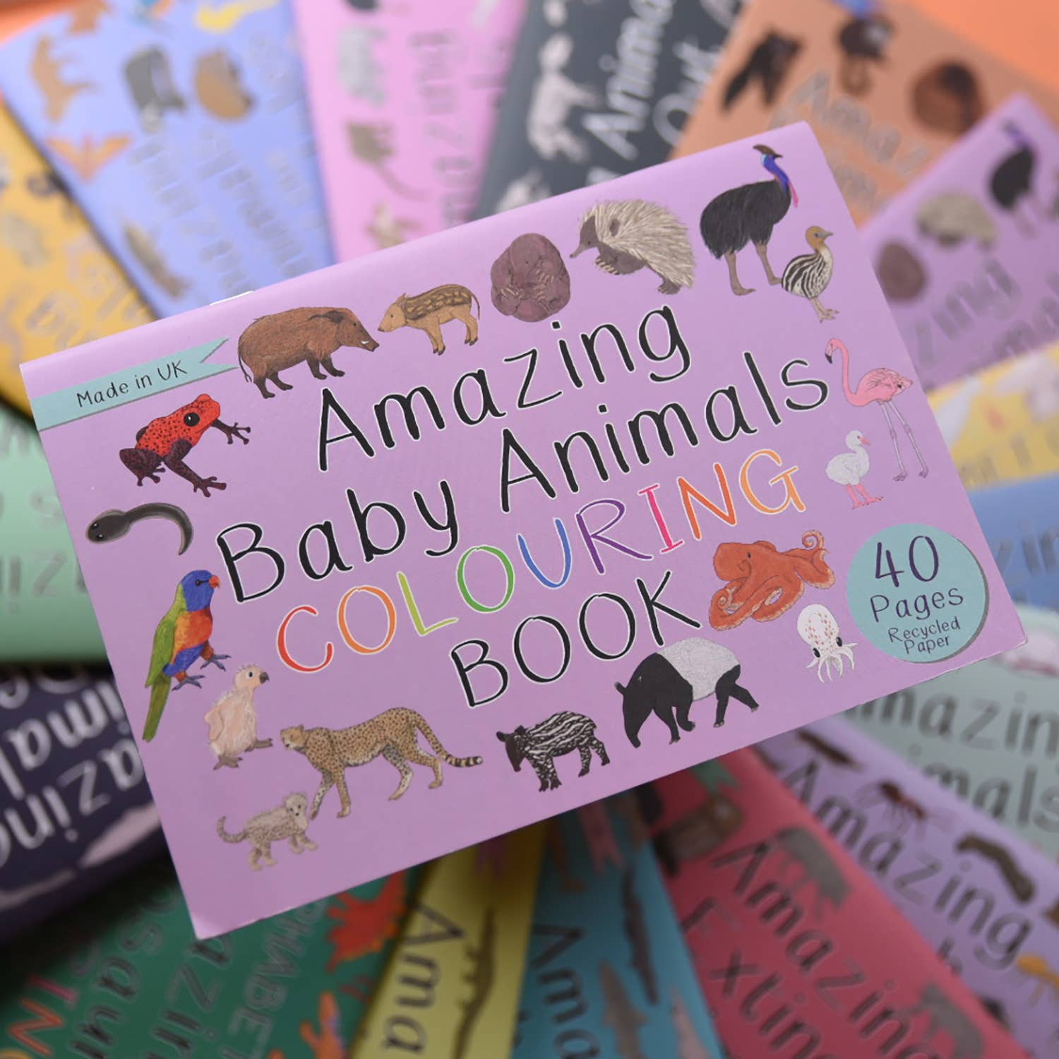 Colorful 'Amazing Baby Animals Colouring Book' with animal illustrations on a stack of similar books.