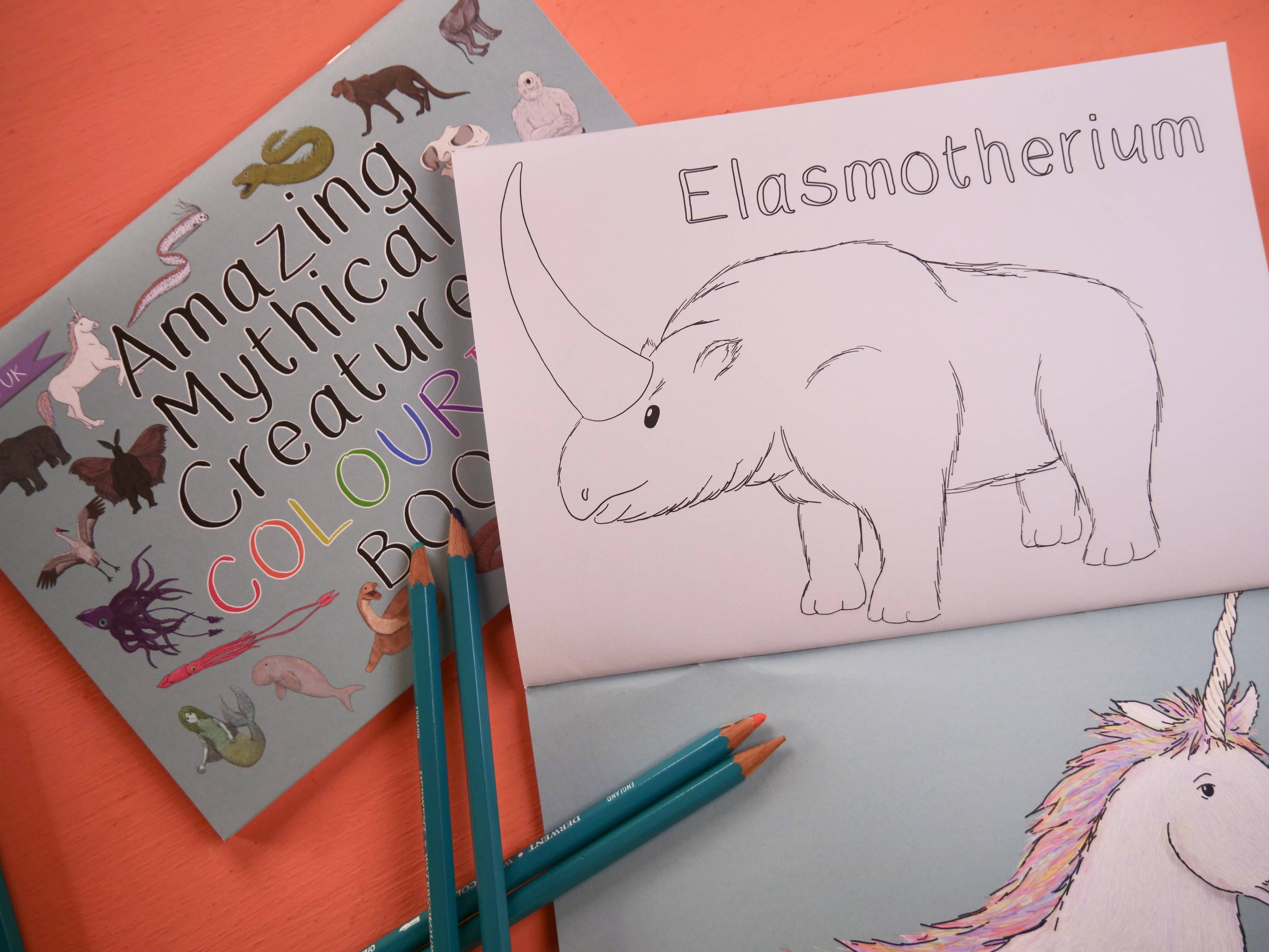 Coloring book with 'Elasmotherium' and pencils on a colorful background