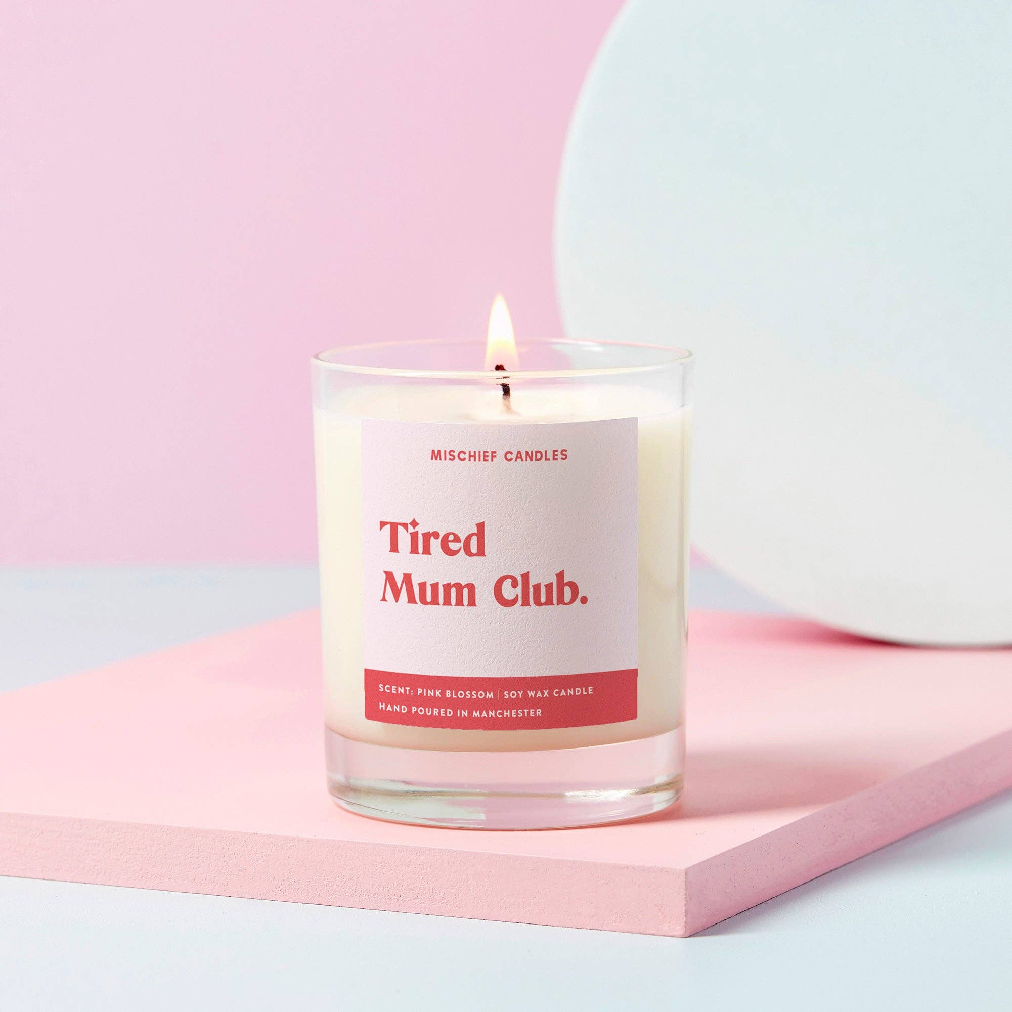 soy wax candle with label 'Tired mum club' in clear glass jar
