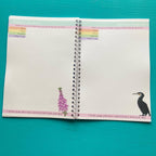 Open nature journal with illustrations of a flower and a bird on a teal background