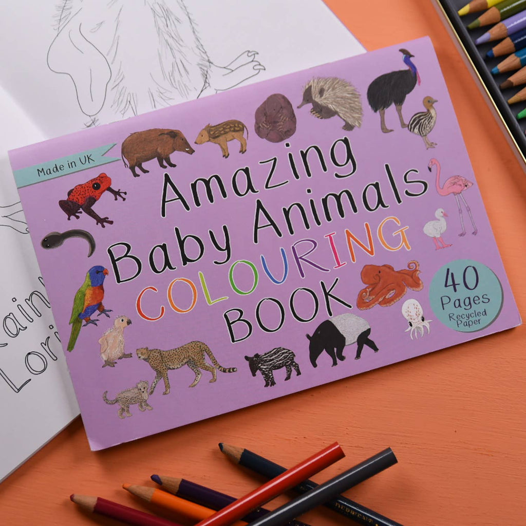 Coloring book titled 'Amazing Baby Animals' with illustrations of various animals on a purple cover, surrounded by coloring pencils.