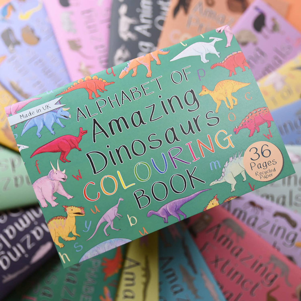 Colorful children's colouring book with dinosaur illustrations on a stack of similar books.