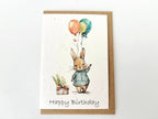 Birthday card with a rabbit holding balloons and a gift, on a white background