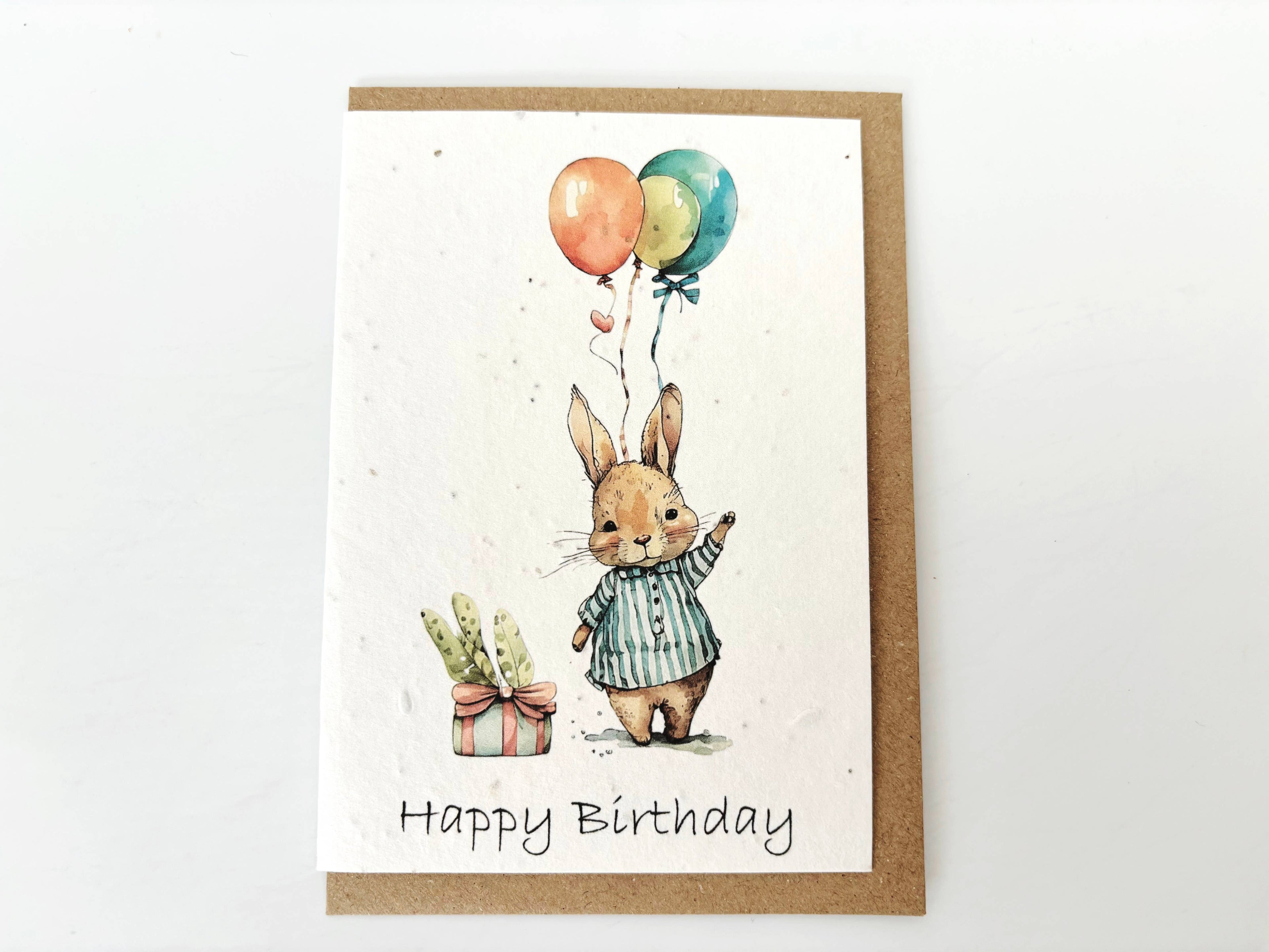 Birthday card with a rabbit holding balloons and a gift, on a white background