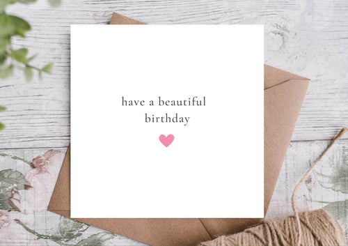 Greeting card with 'have a beautiful birthday' text and heart on a textured surface.
