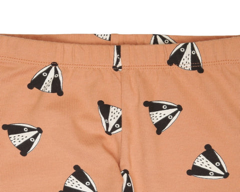 Peach leggings with badger heads printed all over, black cuffs.